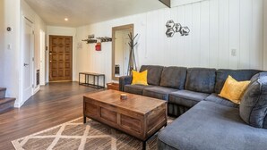 A living room with a sectional sofa, a wooden coffee table, and a patterned rug. - Remodeled 1BD+Loft, Sleeps 5, Walk to Town Center + Pool, Spa, Sauna, & Laundry (Mammoth Lakes)