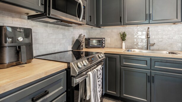 A modern kitchen with stainless steel appliances, a built-in oven, and a microwave. - Remodeled 1BD+Loft, Sleeps 5, Walk to Town Center + Pool, Spa, Sauna, & Laundry (Mammoth Lakes)