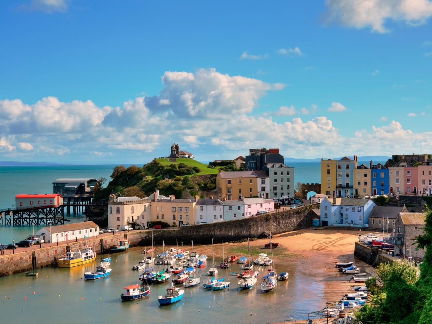 A coastal town with colorful buildings, a pier, and boats docked in the harbor.