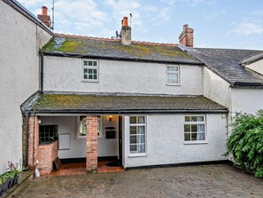 A two-story house with a small attached kitchen, a brick chimney, and a tiled roof. - 2 Bed in Swindon (oc-93489) (Bishopstone)