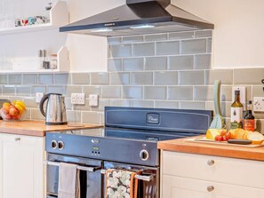 A kitchen with a stove, oven, and a tiled backsplash. - 2 Bed in Swindon (oc-93489) (Bishopstone)