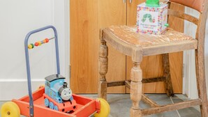 Een speeltreintje op een rails, een houten stoel en een doos met een rupsprint.