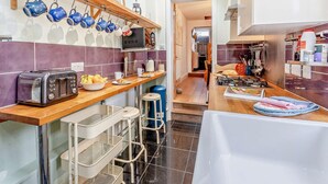 Eine moderne Küche mit Holzarbeitsplatte, integriertem Backofen und einer abgehängten Kochtopfhalterung.