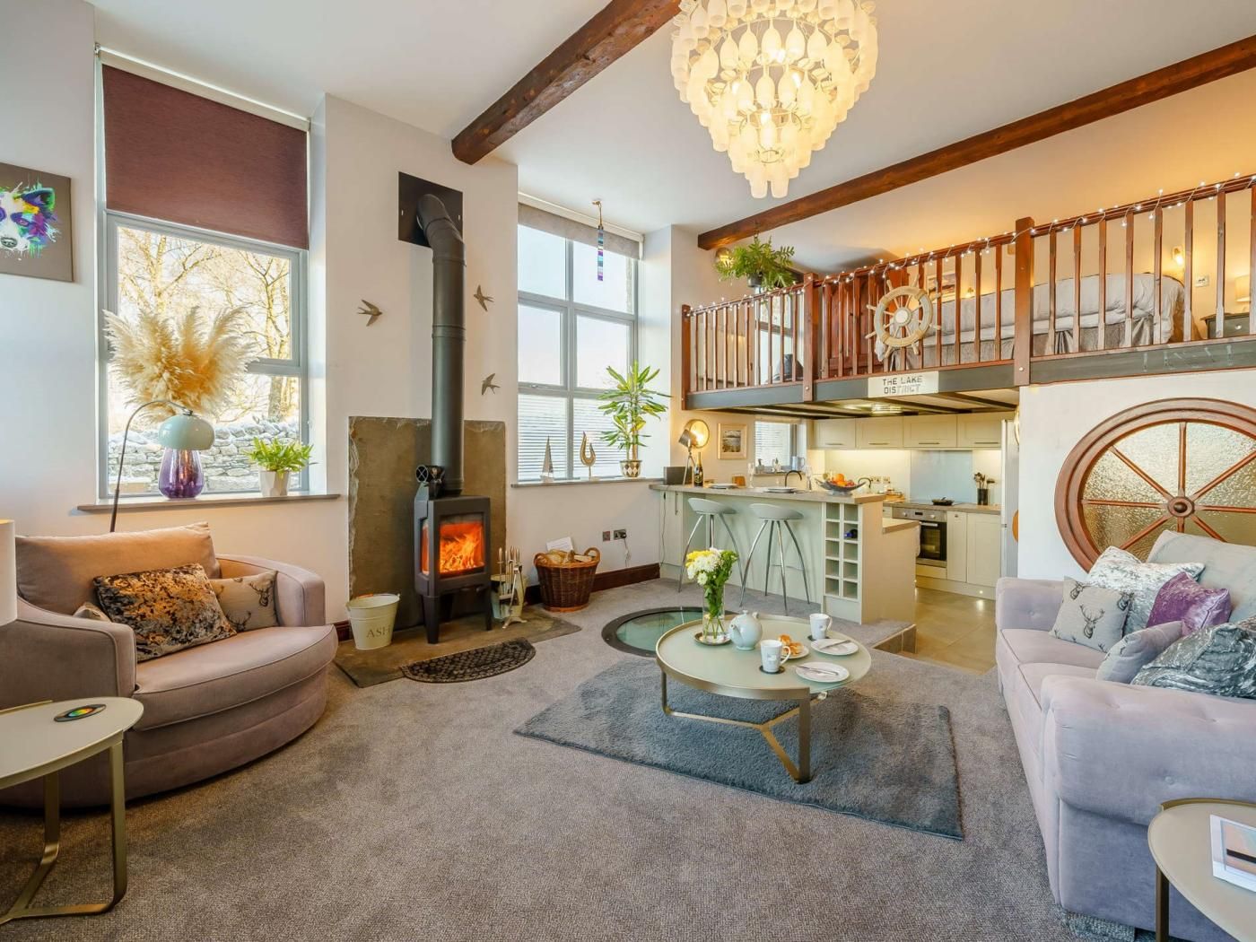 A spacious living area with a fireplace, a dining table, and a kitchen in the background.