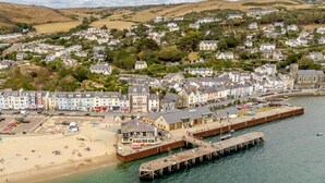 A coastal town with a pier, beach, and residential buildings. - 5 Bed in Aberdovey (oc-93603) (Aberdovey)