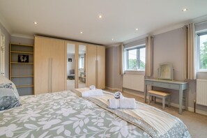 A bedroom with a large bed, a wardrobe, a desk, and a window. - 4 Bed in Ross -on- Wye (oc-72538) (Symonds Yat)