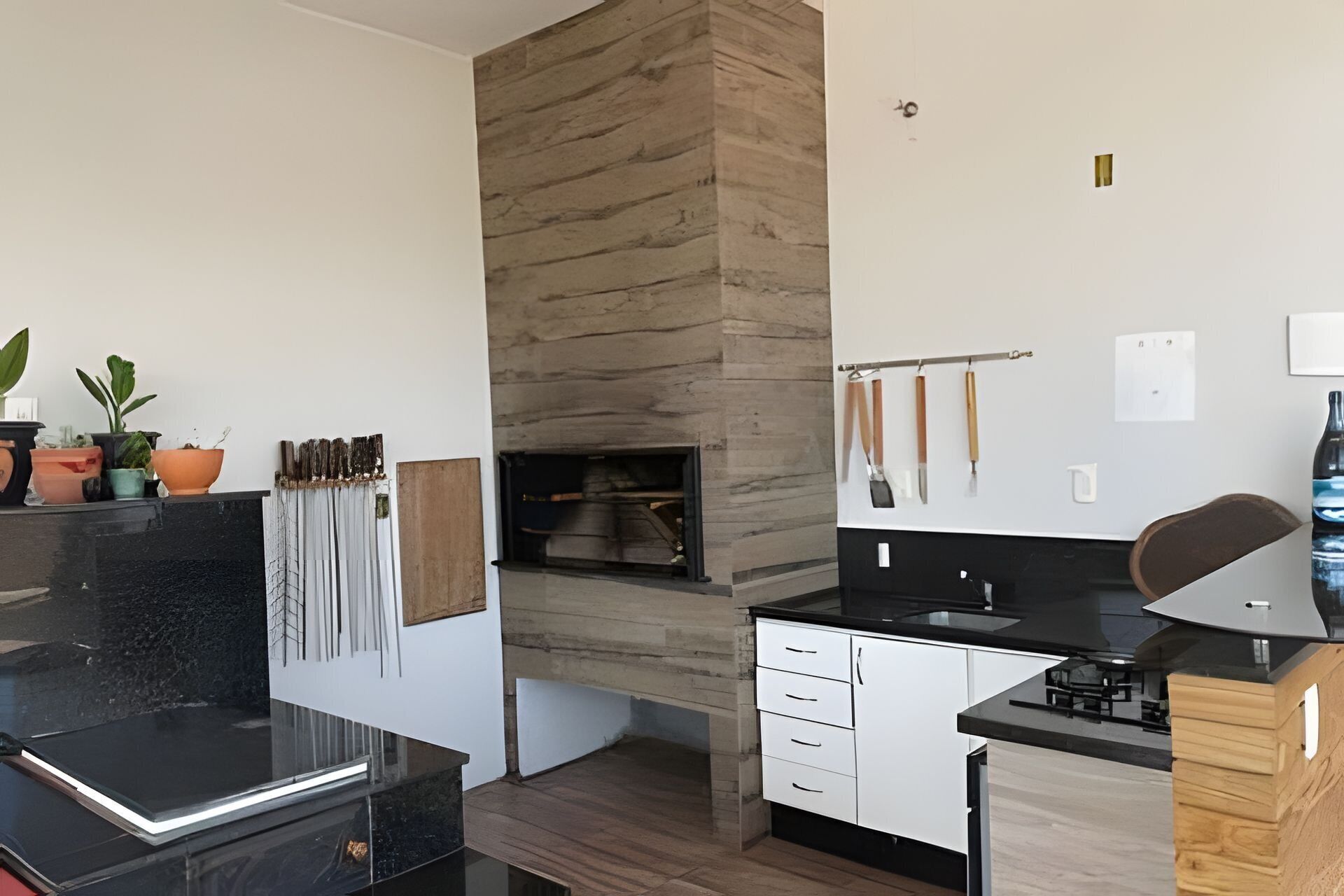 Una cocina moderna con estufa integrada, armarios blancos y encimera negra.
