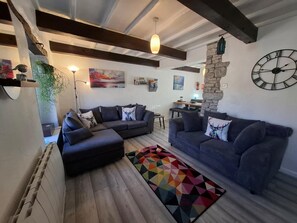 A modern living room with a sectional sofa, a colorful rug, and a stone accent wall. - 3 Bed in Carnforth (oc-90531) (Yealand Redmayne)