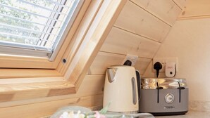 A kitchenette with a toaster, kettle, and a power outlet.