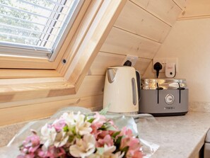 A kitchenette with a toaster, kettle, and a power outlet.