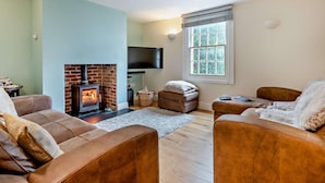 A living room with a fireplace, a television, and a window with blinds. - 3 Bed in Stockbridge (oc-94143) (Broughton)