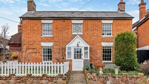 A two-story brick house with a white picket fence, a front door, and a small garden. - 3 Bed in Stockbridge (oc-94143) (Broughton)