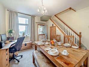 A dining area with a wooden table set for four, a computer desk with a chair, a chandelier, and a staircase. - 2 Bed in Millom (oc-93608) (Millom Without)