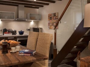A kitchen with a wooden table, a microwave, a toaster, and a basket of bread. - 1 Bed in Grange Over Sands (oc-lcc32) (Lindale)
