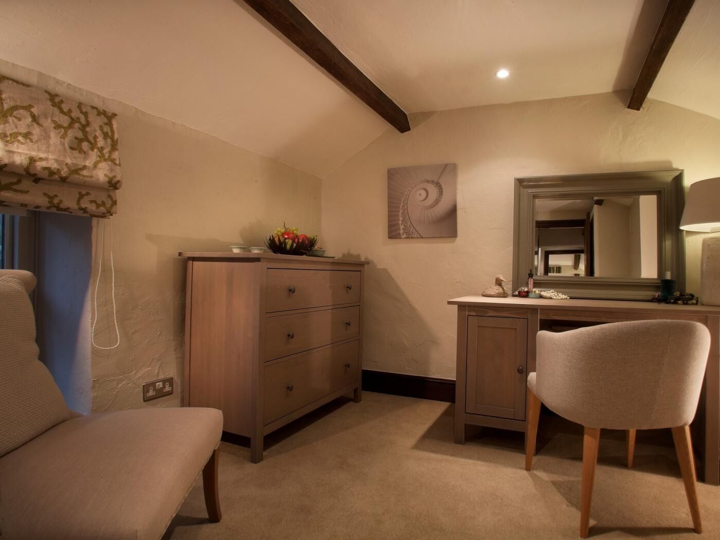 A bedroom with a bed, a dresser, a chair, a mirror, and a wall art piece.
