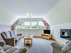 A living room with a sofa, a coffee table, a TV, and a fireplace. - 3 Bed in Crediton (oc-waie2) (Zeal Monachorum)