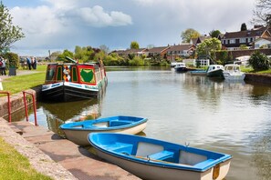 Ein Kanal mit einem Leichter und Hausbooten, umgeben von Häusern und kleinen Booten.