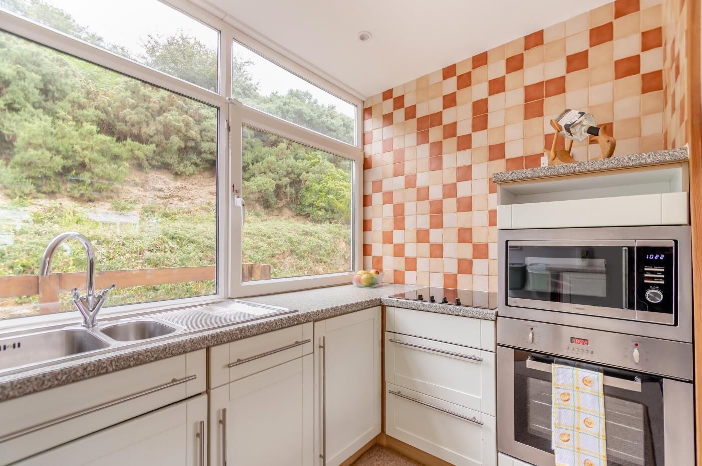 A kitchen with a window, a microwave, and a stove.