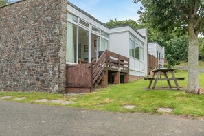 A modern building with a stone facade, large windows, and a wooden deck. - 2 Bed in Nolton Haven (oc-fb098) (Nolton Haven)