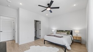 A bedroom with a bed, a ceiling fan, a nightstand, and a white rug. - 2BR South Congress Condo for 6, Near DT! (Austin)
