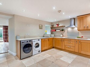 A modern kitchen with built-in appliances, wooden cabinets, and a large window. - 4 Bed in Matlock (oc-93830) (Crich)