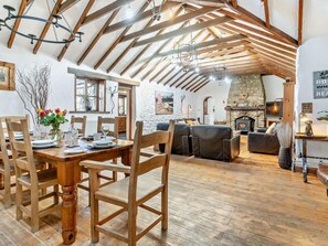 A rustic interior with exposed wooden beams, a stone fireplace, and a dining area with wooden furniture. - 3 Bed in Swansea (oc-93942) (Southgate)