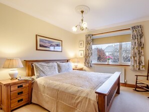 A bedroom with a bed, bedside tables, a lamp, a picture on the wall, a window with curtains, and a radiator. - 3 Bed in Keswick (oc-93949) (Portinscale)