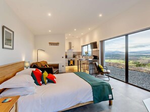A modern bedroom with a large bed, a desk, and a view of the countryside. - 1 Bed in Ardgay (oc-90471) (Migdale)
