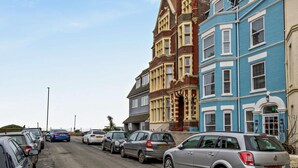 A street with parked cars and colorful Victorian-style buildings. - 2 Bed in Cromer (oc-91297) (Cromer)