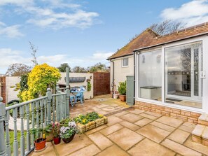 A residential property with a patio, outdoor seating, and a conservatory. - 1 Bed in Worthing (oc-80539) (Worthing)