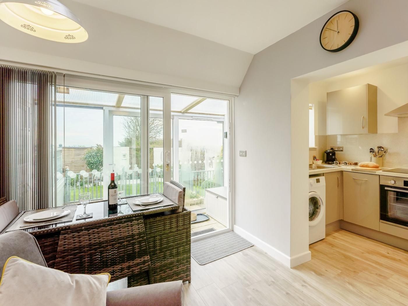 A modern apartment with a dining area, kitchen, and a view of the outdoors.