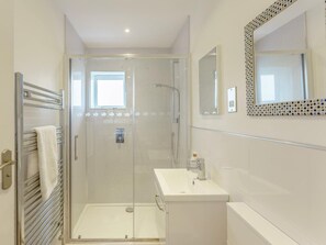 A modern bathroom with a glass-enclosed shower, a white sink, and a mirror with a decorative frame. - 1 Bed in Worthing (oc-80539) (Worthing)