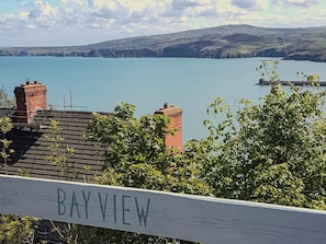 Blick auf eine Bucht, im Vordergrund eine Holzbrüstung mit der Aufschrift 'BAYVIEW'.