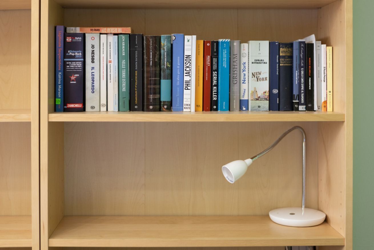 Ein Bücherregal mit Büchern und einer Schreibtischlampe.