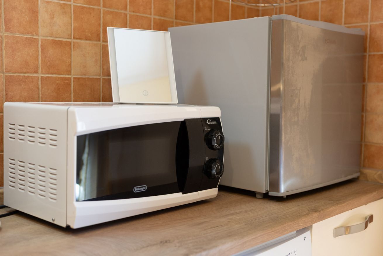 Eine Mikrowelle und ein Kühlschrank auf einer Küchenarbeitsplatte.