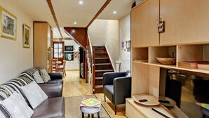 A living room with a sofa, ottoman, and a TV stand with shelves. - 3 Bed in Skipton (oc-93485) (Embsay)