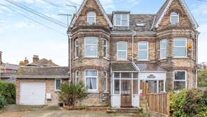Une maison à deux étages avec une baie vitrée, une porte d’entrée et un garage.