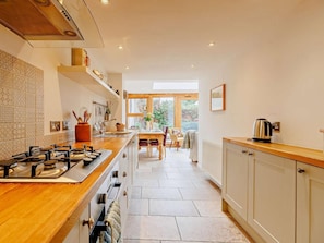 Een moderne keuken met een centraal eiland, een eethoek met uitzicht en een aanrecht met inbouwapparatuur.