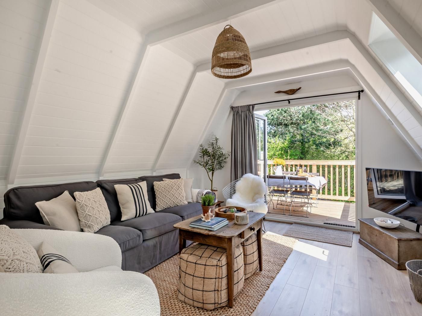 Ein Loft-Wohnzimmer mit einer Couch, einem Couchtisch und Blick ins Freie.