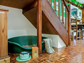 A wooden staircase, a green sofa, a leopard print chair, a ceramic teapot, and a box of tea. - 2 Bed in Skipton (oc-93484) (Embsay)
