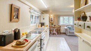 Una cucina con tostapane, bollitore e un'area pranzo con tavolo e sedie.