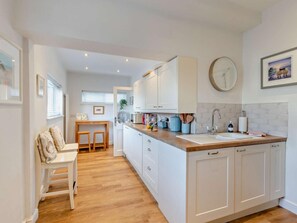 A modern kitchen with white cabinetry, a wooden countertop, and a built-in oven. - 4 Bed in Morpeth (oc-93510) (Amble)