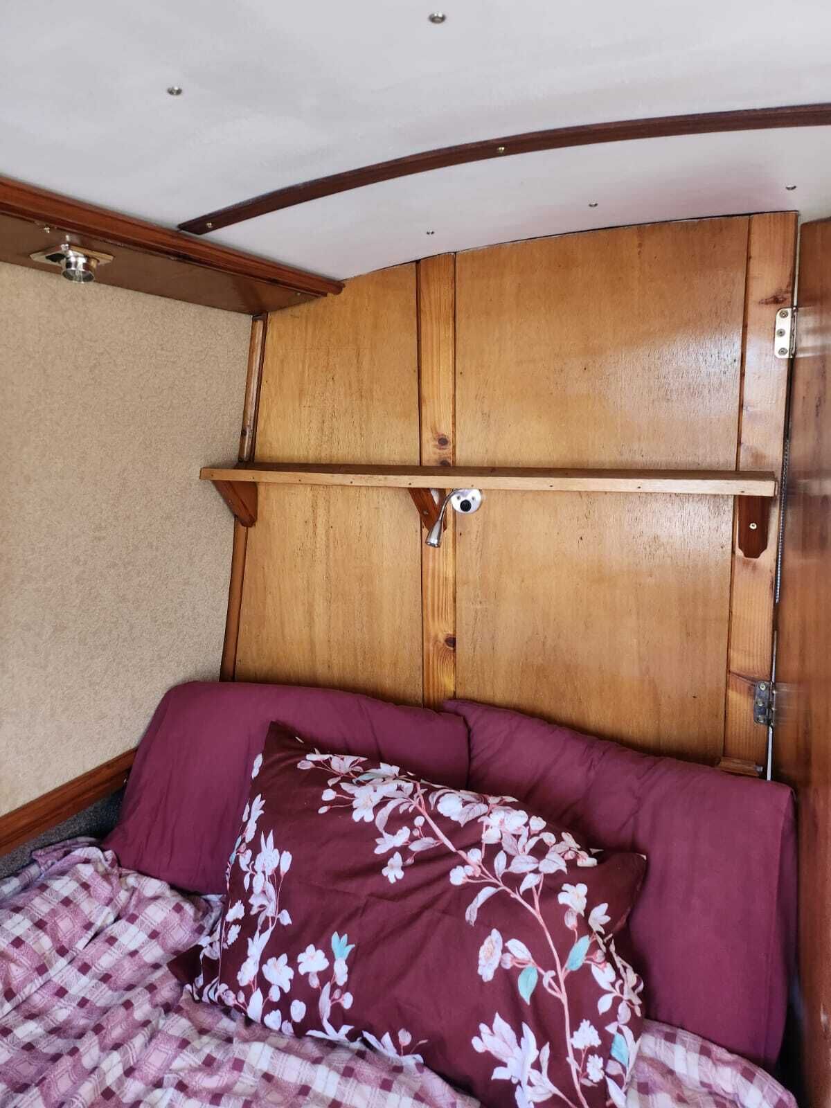 A room with a bed, a wooden headboard, and a ceiling fan.