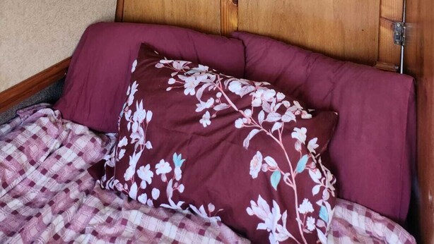 A room with a bed, a wooden headboard, and a ceiling fan. - Lovely Narrowboat Chiltern Hills and Surrounding. (Hemel Hempstead)