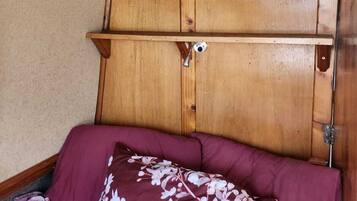 A room with a bed, a wooden headboard, and a ceiling fan.