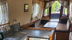 A compact kitchen with a gas stove, a sink, and a small refrigerator. - Lovely Narrowboat Chiltern Hills and Surrounding. (Hemel Hempstead)