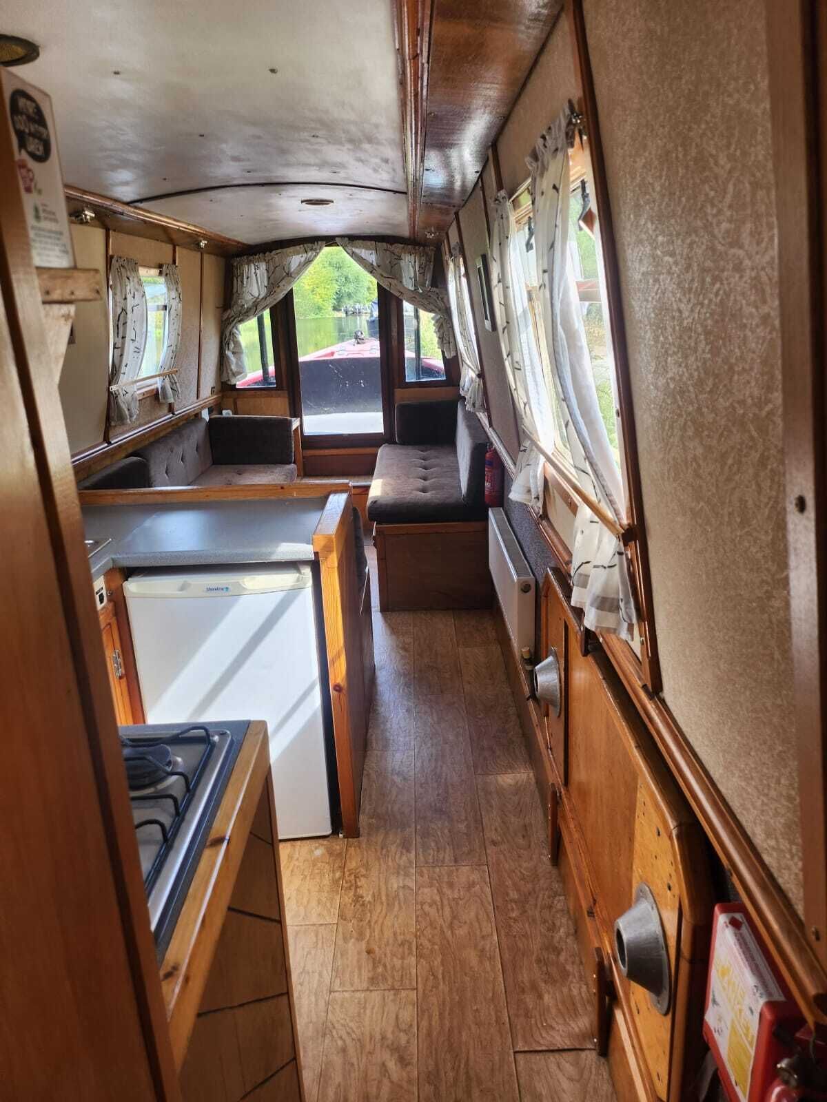 A compact kitchen with a stove, sink, and seating area.