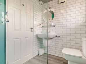 A bathroom with white subway tiles, a glass shower enclosure, a white sink, and a toilet. - 2 Bed in Helston (oc-54556) (Mullion)