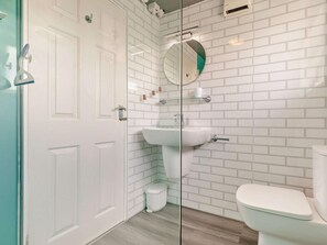 A bathroom with white subway tiles, a glass shower enclosure, a white sink, and a toilet. - 2 Bed in Helston (oc-54556) (Mullion)
