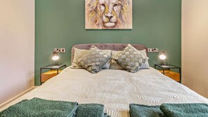 A bedroom with a bed, two bedside lamps, a green wall, and a lion painting. - 2 Bed in Knighton (oc-94202) (Knighton)